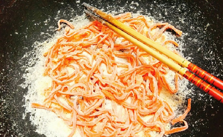 Bắc chảo lên bếp, cho toàn bộ cà rốt đã ngâm đường vào chảo và bắt đầu sên mứt.